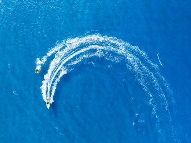 Tatil ve boş zaman. Motorlu deniz manzaralı. Güneşli bir günde mavi denizde hızlı teknenin hava manzarası. Deniz yüzeyinde hızlı gemi. Drone 'dan deniz pelerini. Arkaplan, duvar kağıdı, kartpostal.