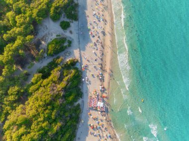 Kumsaldaki hava manzarası, insanlar ve şemsiyeler. Tatil ve macera. Avrupa, Akdeniz 'e. Kumsaldaki ve gök mavisi denizdeki İHA 'nın üst görüntüsü. İHA 'dan sahile bak. 
