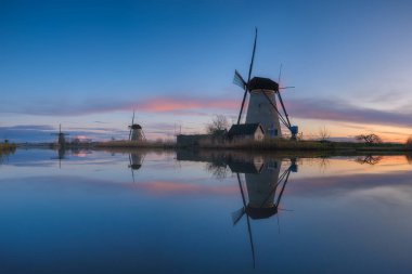 Gün batımında Hollanda 'da yel değirmenleri. Tarihi mimari ve binalar. Hollanda kanalları. Doğa manzarası. Arkaplan, duvar kağıdı, kartpostallar için fotoğraf.