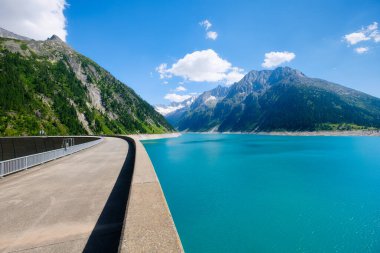 Avusturya 'da göl, baraj ve yüksek dağ sıraları. Yaz boyunca dağ manzaraları. Sıcak güneşli hava ve açık gökyüzü. Dağ yürüyüşü, seyahat ve tatil için bir yer. Duvar kağıdı, kartpostal, fotoğraf..