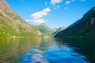 Norveç. Fiyortlarda doğa. Yüksek dağlar ve su yüzeyindeki yansımalar. İskandinavya. Norveç 'te yaz tatili ve seyahat. Dağ yürüyüşü, seyahat ve tatil için bir yer. Duvar kağıdı, kartpostal, arkaplan.