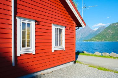 Geleneksel İskandinav kırmızı evleri. Norveç 'teki güzel dağ gölü. Fiyortlarda doğa. Norveç 'te yaz tatili ve seyahat. Duvar kağıdı, kartpostal, arkaplan.