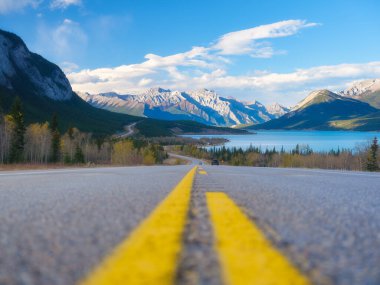 Asfalt yolu. Ufuktaki yüksek dağlar. Seyahat yönü. Tatil ve arabayla seyahat. Duvar kağıdı, arka plan, kartpostal. Doğa ve altyapı.