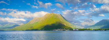 Norveç. Fiyortlarda doğa. Yüksek dağlar ve yansımalar. Panoramik manzara. Kayaların üzerindeki bulutlar. Norveç 'te yaz tatili ve seyahat. Arkaplan, duvar kağıdı, kartpostallar.