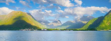 Norveç. Fiyortlarda doğa. Yüksek dağlar ve yansımalar. Panoramik manzara. Kayaların üzerindeki bulutlar. Norveç 'te yaz tatili ve seyahat. Arkaplan, duvar kağıdı, kartpostallar.