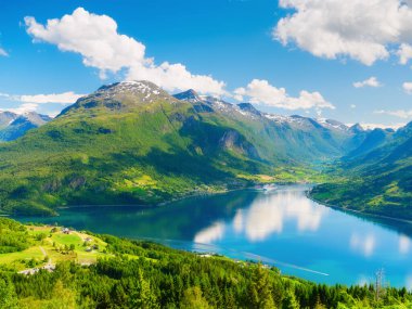 Norveç. Norveç fiyordunda bir gemi turu. Yüksek dağlar ve su yüzeyindeki yansımalar. Kayaların üzerindeki bulutlar. Norveç 'te yaz tatili ve seyahati.