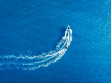 Tatil ve boş zaman. Motorlu deniz manzaralı. Güneşli bir günde mavi denizde hızlı teknenin hava manzarası. Deniz yüzeyinde hızlı gemi. Drone 'dan deniz pelerini. Arkaplan, duvar kağıdı, kartpostal.