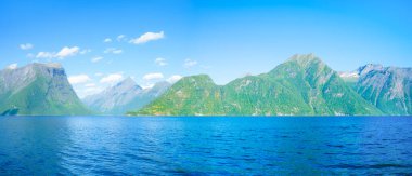 Norveç 'teki güzel dağ gölü. Fiyortlarda doğa. Yüksek dağlar ve su yüzeyindeki yansımalar. Kayaların üzerindeki bulutlar. Norveç 'te yaz tatili ve seyahati.