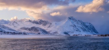 Norveç. Fiyortlarda doğa. Yüksek dağlar ve yansımalar. Fiyortta gün batımı. Kayaların üzerindeki bulutlar. Norveç 'te kış tatili ve seyahat. Arkaplan, duvar kağıdı, kartpostallar.