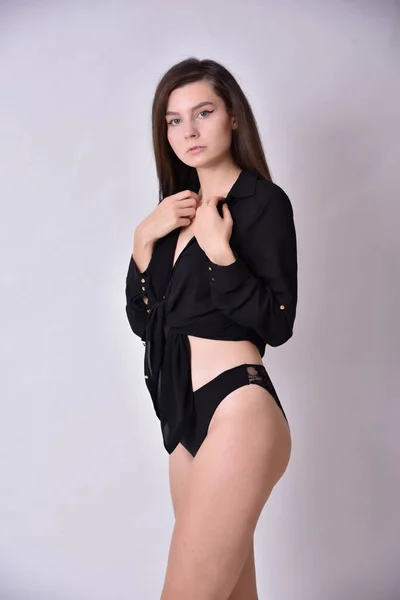 若い女だブルネット ブラックトップとブラックの下着を持つ女性モデル 白い背景 スタジオの写真 — ストック写真