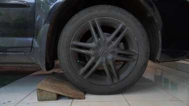 siyah araba tekerlekleri, kirli tozlu soyma, araba gövdesine yapışmış çamur, tekerlekler ahşap Purworejo Endonezya ile desteklenmiş - 28 Mayıs 2023