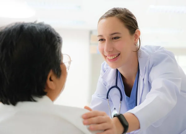 Ung Kvinnlig Läkare Hälsoundersökning Till Gammal Kvinnlig Patient Som Sitter — Stockfoto