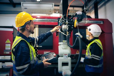 Robot makine atölyesinde robot kol makinesi eğitimi alan çok ırklı taşikardi mühendisi..