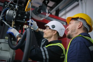 Robot makine atölyesinde robot kol makinesi eğitimi alan çok ırklı taşikardi mühendisi..