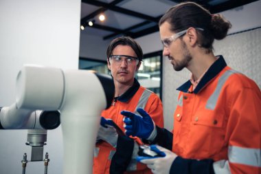 Robot makine atölyesinde robot kol makinesi eğitimi alan çok ırklı taşikardi mühendisi..