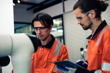 Robot makine atölyesinde robot kol makinesi eğitimi alan çok ırklı taşikardi mühendisi..