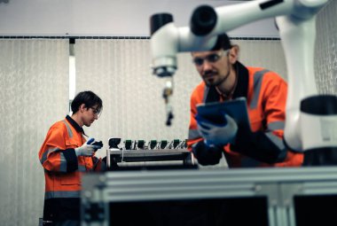 Robot makine atölyesinde robot kol makinesi eğitimi alan çok ırklı taşikardi mühendisi..
