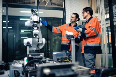 Robot makine atölyesinde robot kol makinesi eğitimi alan çok ırklı taşikardi mühendisi..