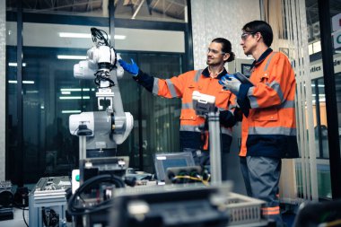 Robot makine atölyesinde robot kol makinesi eğitimi alan çok ırklı taşikardi mühendisi..