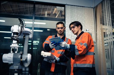 Robot makine atölyesinde robot kol makinesi eğitimi alan çok ırklı taşikardi mühendisi..