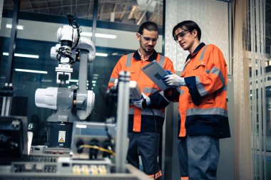 Robot makine atölyesinde robot kol makinesi eğitimi alan çok ırklı taşikardi mühendisi..