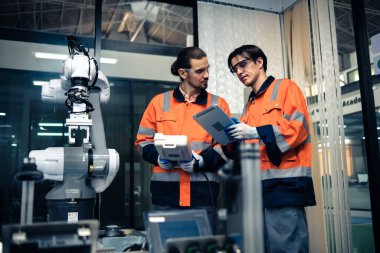 Robot makine atölyesinde robot kol makinesi eğitimi alan çok ırklı taşikardi mühendisi..