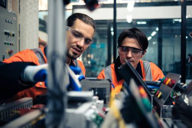 Robot makine atölyesinde robot kol makinesi eğitimi alan çok ırklı taşikardi mühendisi..