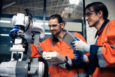 Robot makine atölyesinde robot kol makinesi eğitimi alan çok ırklı taşikardi mühendisi..