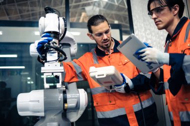 Robot makine atölyesinde robot kol makinesi eğitimi alan çok ırklı taşikardi mühendisi..