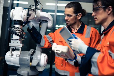 Robot makine atölyesinde robot kol makinesi eğitimi alan çok ırklı taşikardi mühendisi..