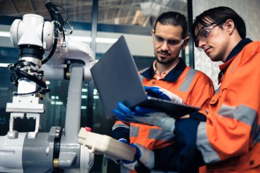 Robot makine atölyesinde robot kol makinesi eğitimi alan çok ırklı taşikardi mühendisi..