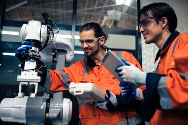 Robot makine atölyesinde robot kol makinesi eğitimi alan çok ırklı taşikardi mühendisi..