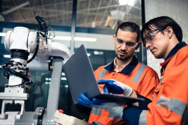 Robot makine atölyesinde robot kol makinesi eğitimi alan çok ırklı taşikardi mühendisi..