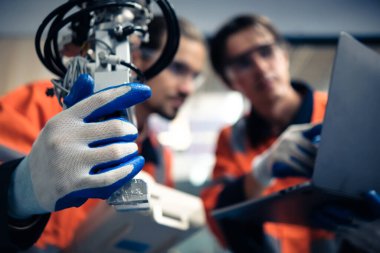 Robot makine atölyesinde robot kol makinesi eğitimi alan çok ırklı taşikardi mühendisi..