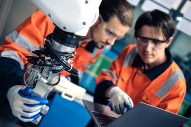 Robot makine atölyesinde robot kol makinesi eğitimi alan çok ırklı taşikardi mühendisi..