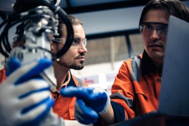 Robot makine atölyesinde robot kol makinesi eğitimi alan çok ırklı taşikardi mühendisi..