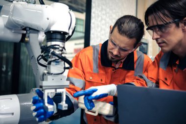 Robot makine atölyesinde robot kol makinesi eğitimi alan çok ırklı taşikardi mühendisi..