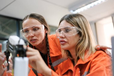 Robot makine atölyesinde robot kol makinesi eğitimi alan çok ırklı taşikardi mühendisi..