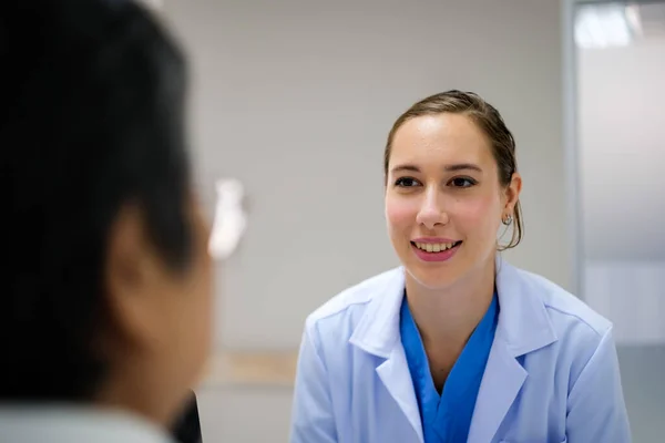 Ung Kvinnlig Läkare Hälsoundersökning Till Gammal Kvinnlig Patient Som Sitter — Stockfoto