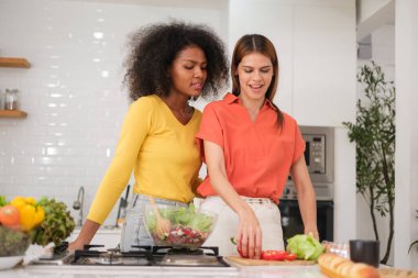 Kitche 'de salata pişiren çok ırklı lezbiyen çift.