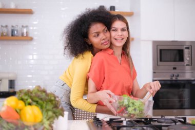 Kitche 'de salata pişiren çok ırklı lezbiyen çift.