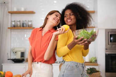 Kitche 'de salata pişiren çok ırklı lezbiyen çift.