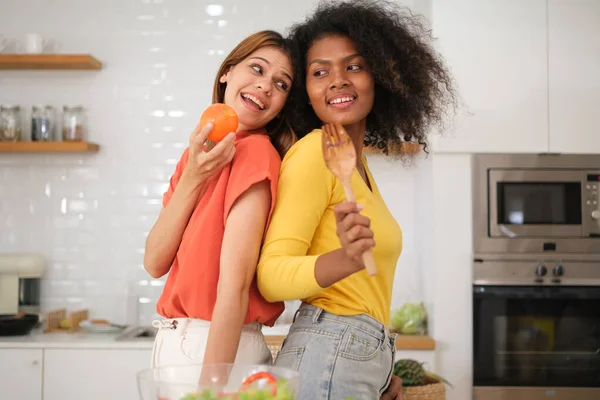 stock image Multiracial Lesbian couple cooking salad in kitche