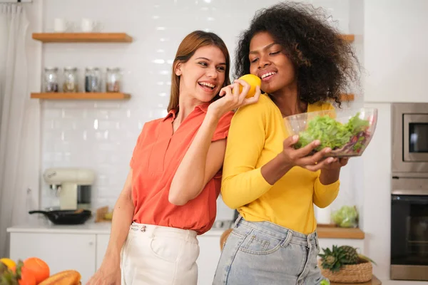 stock image Multiracial Lesbian couple cooking salad in kitche