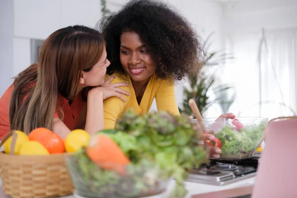 stock image Multiracial Lesbian couple cooking salad in kitche