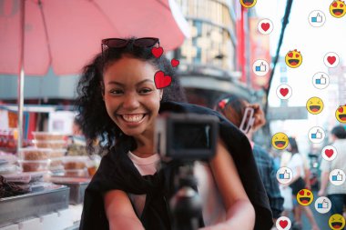 Asyalı kadın şehir merkezinde gezmekten hoşlanıyor ve fotoğraf çekiyor ve sosyal medyada canlı olarak cep telefonu kullanıyor ve sokak yemekleri tadıyor..