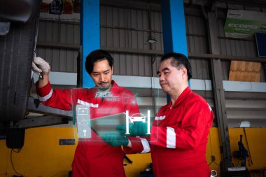 Araba tamircisi teknolojiyi ve bilgisayarı kullanarak arabayı inceliyor. Sanal ekranda reaksiyonu göster.