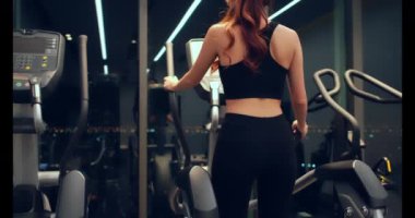 Spor salonundaki spor salonunda egzersiz yapan genç bir kadın.