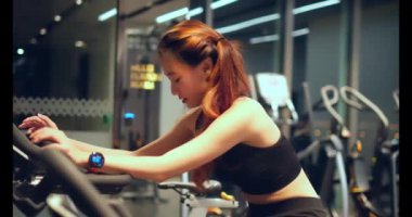 Spor salonundaki spor salonunda egzersiz yapan genç bir kadın.