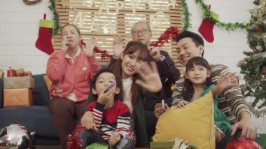 Mutlu Asyalı aile Noel 'de ve yeni yılda kameraya bakıp el sallamaktan zevk alır..